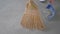 Man sweeps trash with a broom sweeping into a scoop