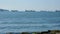 Man swimming along the shore. Sea view. Boats, ships, tankers, yachts