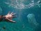 A man swimming among toxic plastic wastes floating in the ocean