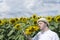 Man with syndrome down smelling sunflowers in the field. Enjoying sun lights and nature