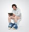 Man with tablet pc and headphones sitting on the toilet