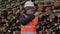 Man with a tablet PC numbering near log pile