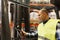 Man with tablet pc operating forklift at warehouse