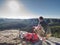 Man take break for snack while climbing in rocks. Hiker in shorts