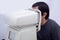Man take eye exam with optical eye test machine