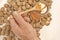 Man takeing honey from a jar, walnuts on table