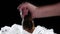 Man takes a bottle of beer from the ice. Black background. Close up. Slow motion