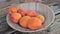 A man takes fresh apricot fruits from the plate