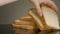 Man takes one slice of cut bread lying on reflective surface of the table. Stock footage. Close up view of white organic