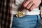 Man takes out gold-colored condom from his jeans pocket. Prevention of sexually transmitted diseases and AIDS. Sensible