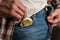 Man takes out gold-colored condom from his jeans pocket. Prevention of sexually transmitted diseases and AIDS. Sensible