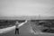 A man takes a photo of the road that leads to the Corrubedo lighthouse