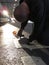 A man takes picture of a fallen dry leaf on a train station platform