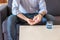 man takes pills drinks glass of water and is sitting on the sofa