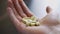 Man takes and shows pills of vitamins or medicines in the hands of a pill bottle