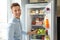 Man taking apple out of refrigerator