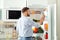 Man taking bottle with juice out of refrigerator