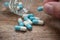 man taking capsules and drug tablets falling from bot