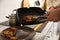 Man taking cooked tasty meat from frying pan, closeup