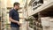 Man is taking different woven baskets from racks in a shop, choosing