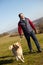 Man Taking Dog On Walk In Autumn Countryside