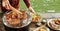 Man taking grilled meat off a BBQ outdoors