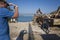 Man taking photo of aged large rusty metal industrial structure for transporting boats in harbour with old bicycle