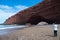 Man taking photo of Legzira rock formation - horizontal