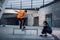 man taking photo of skateboarder jumping over bench