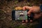 Man taking picture of the mushroom in the woods. Taking pictures using mobile phone. Mobile photography