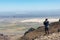 A man taking pictures of Alvord desert from Steens Mountain summit desert