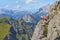 Man taking pictures secured to a via ferrata cable, high up on Delle Trincee klettersteig, in the Dolomites mountains