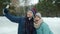 Man taking selfie with laughing girlfriend using smartphone camera at ice skating rink