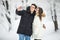 Man taking selfie photo young romantic couple smile snow forest outdoor winter pine woods. Couple make selfie.