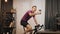 Man taking selfie while training on exercise bicycle at home. Indoor cycling, home sport activity. Young smiling cyclist is cyclin