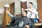 Man Taking Selfportrait On Smartphone While Hairdresser Styling