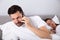 Man talking secretly on cellphone while his wife sleeping