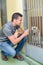 Man talking to dog through kennel door