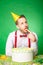 Man tasting birthday cake on green background