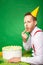 Man tasting birthday cake on green background