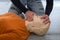 Man teaching cardiopulmonary resuscitation with a dummy on a white background. Opening airways and covering the nose to prepare