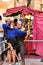 Man teaching a girl archery at a market stall