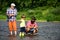 Man teaching kids how to fish in river. Father, son and grandfather fishing. Generations men. Three generations ages