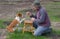 Man teaching smart basenji dog simple tricks