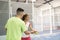 Man teaching woman how to play paddle tennis