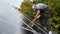 Man technician mounting photovoltaic solar panels on roof of house with help of hex key.