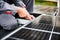 Man technician mounting photovoltaic solar panels on roof of house with help of hex key.