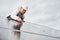 Man technician mounting photovoltaic solar panels on roof of house with help of hex key.