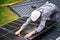 Man technician mounting photovoltaic solar panels on roof of house with help of hex key.