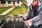 Man technician mounting photovoltaic solar panels on roof of house with help of hex key.